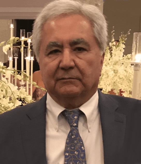 Portrait of an elderly man in a suit and tie at a formal event.
