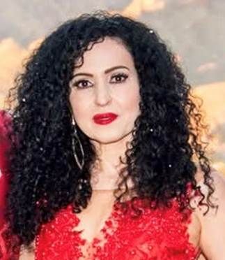 Woman with curly hair wearing a red dress.